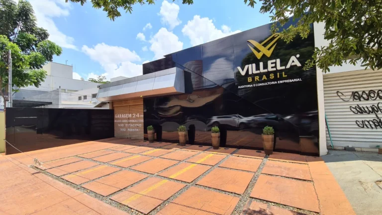 Fachada Villela com revestimento escuro e letreiro dourado
