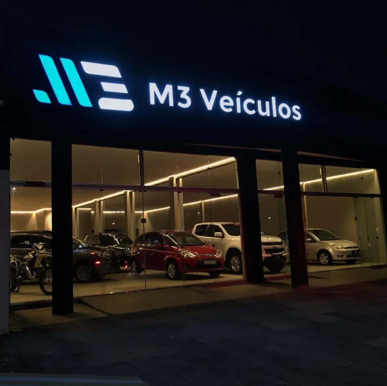 Letreiro M3 Veículos iluminado à noite