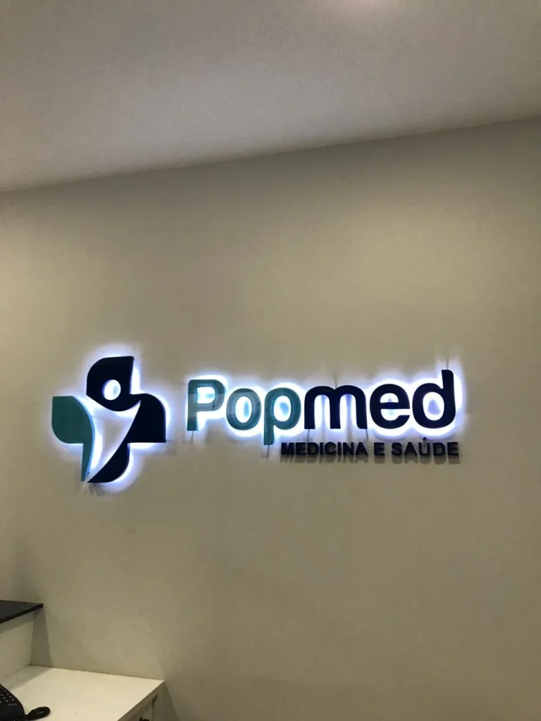 Letreiro Popmed iluminado em ambiente interno