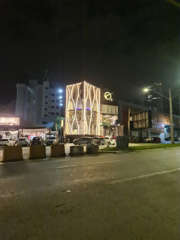 Vista noturna de fachada comercial iluminada